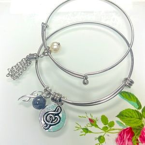 Set of 2 bangle bracelets. Beautiful music note charm engraved saying on back